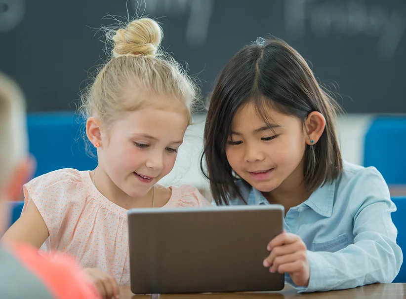 Two young girls using a tablet together