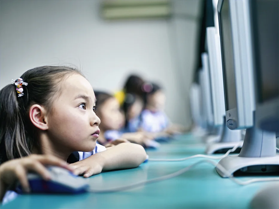 A girl concentrating at a computer in class