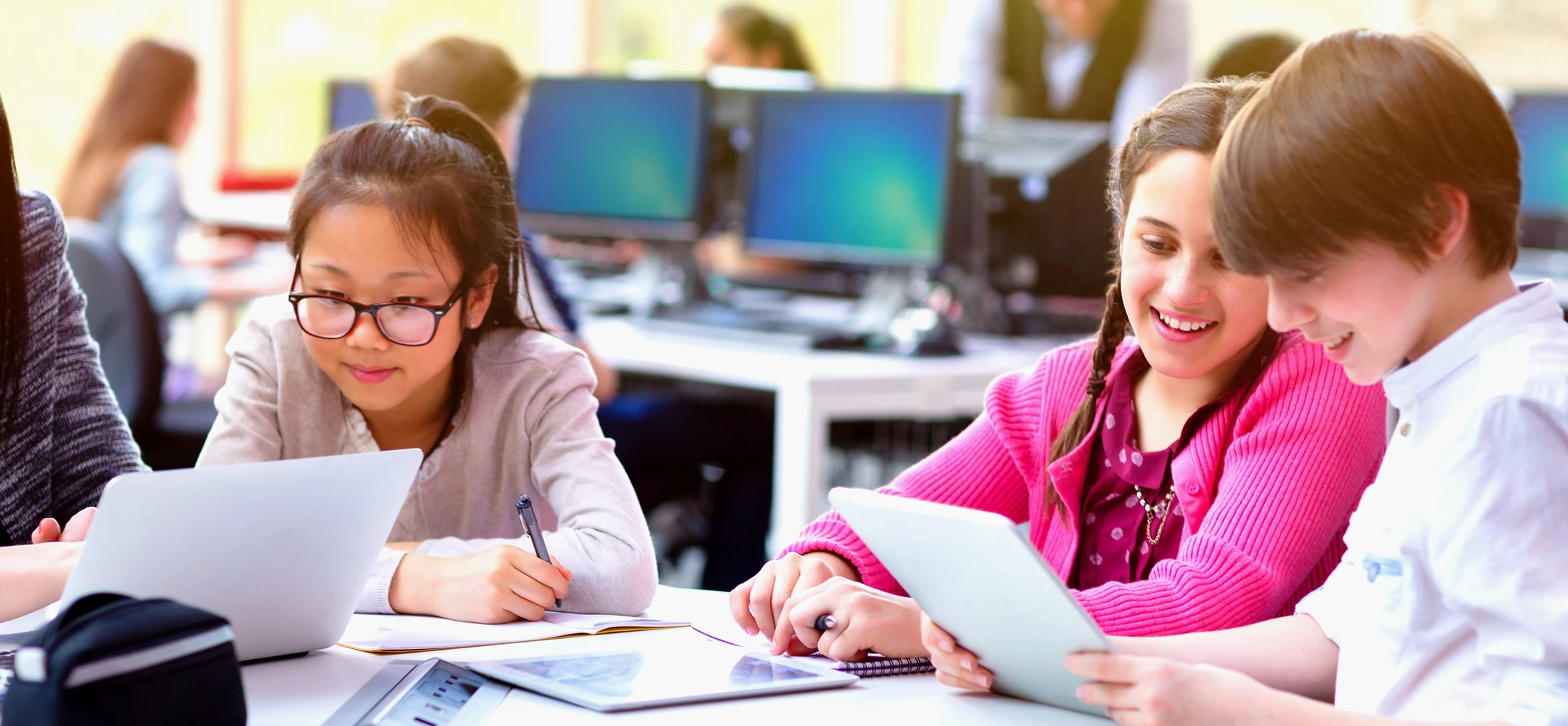 Children working together on school work in a computer lab