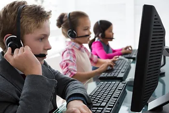 Students learning with AI on computers and headphones