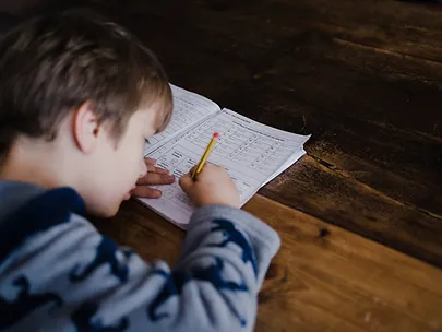 Young boy writing and working in a workbook