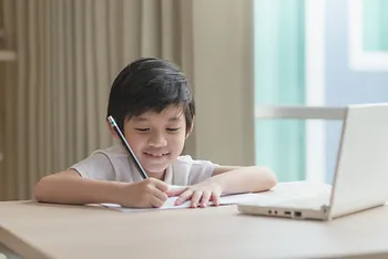 A young boy writing.